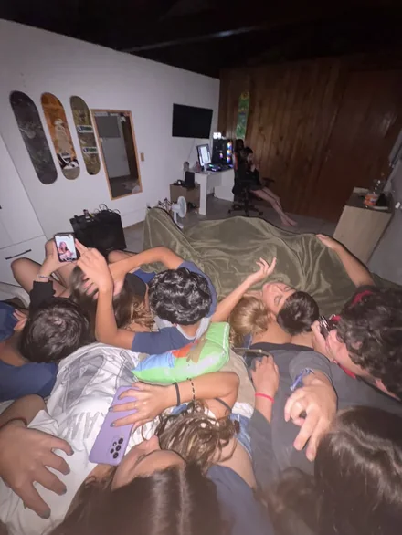 Friends piled on a bed